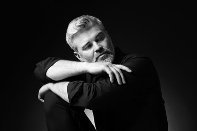 Portrait of handsome man on dark background. Black and white effect