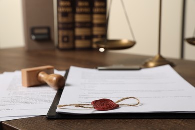 Documents and stamp on wooden table, closeup. Notary contract