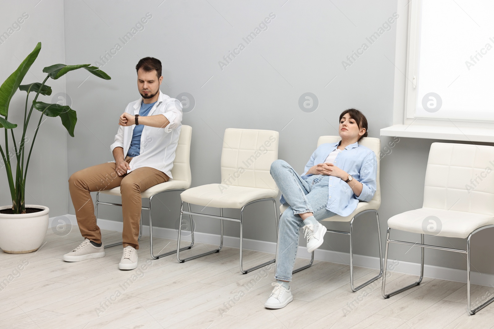 Photo of Man and woman waiting for appointment indoors