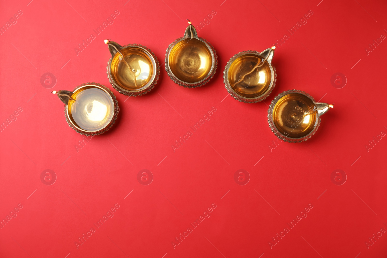Photo of Diwali diyas or clay lamps on color background, top view