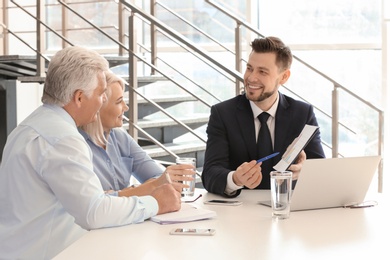 Photo of Male manager consulting mature couple in office