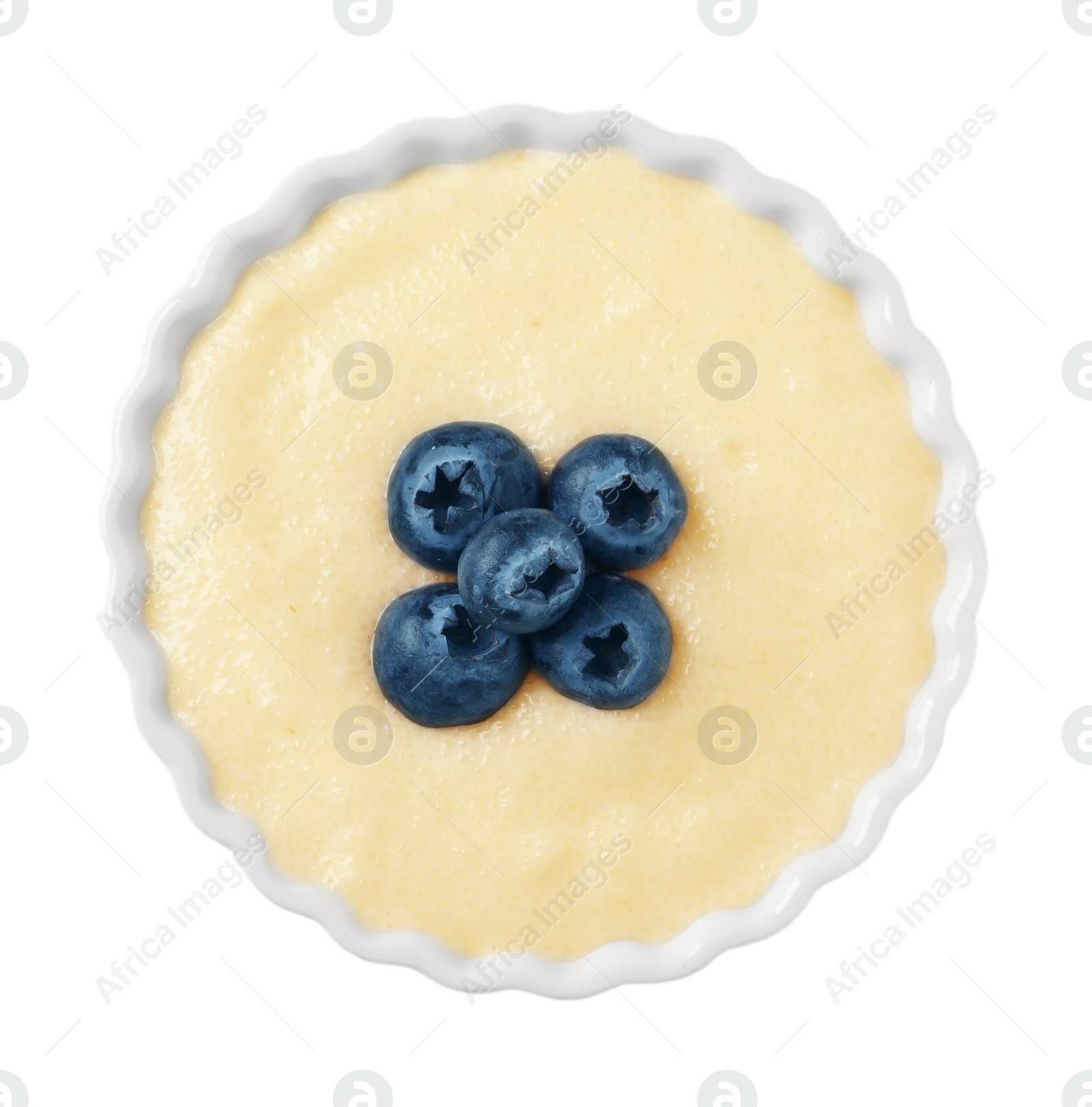 Photo of Delicious semolina pudding with blueberries in bowl on white background, top view