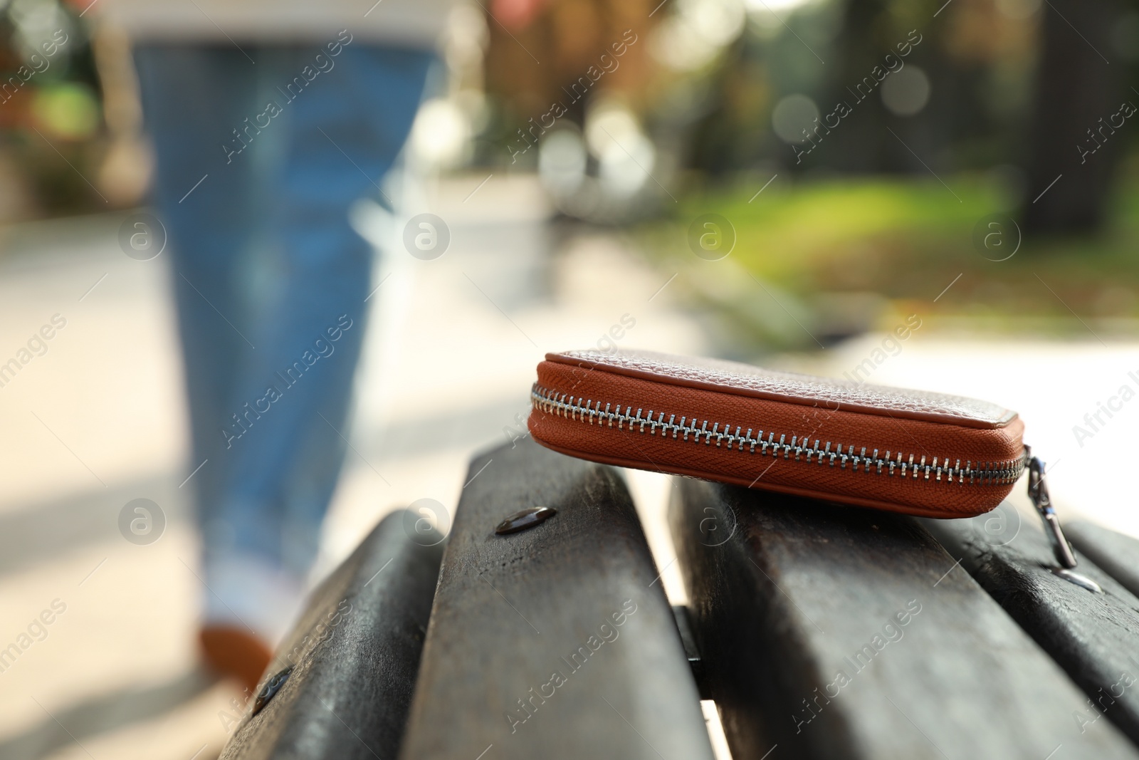 Photo of Woman lost her purse on wooden surface outdoors, selective focus. Space for text