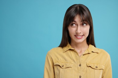 Photo of Embarrassed woman on light blue background, space for text