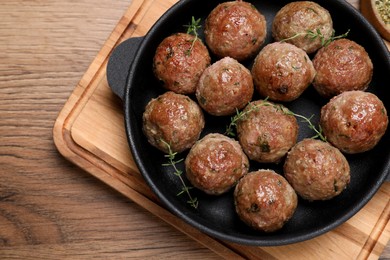 Photo of Tasty cooked meatballs on wooden table, flat lay