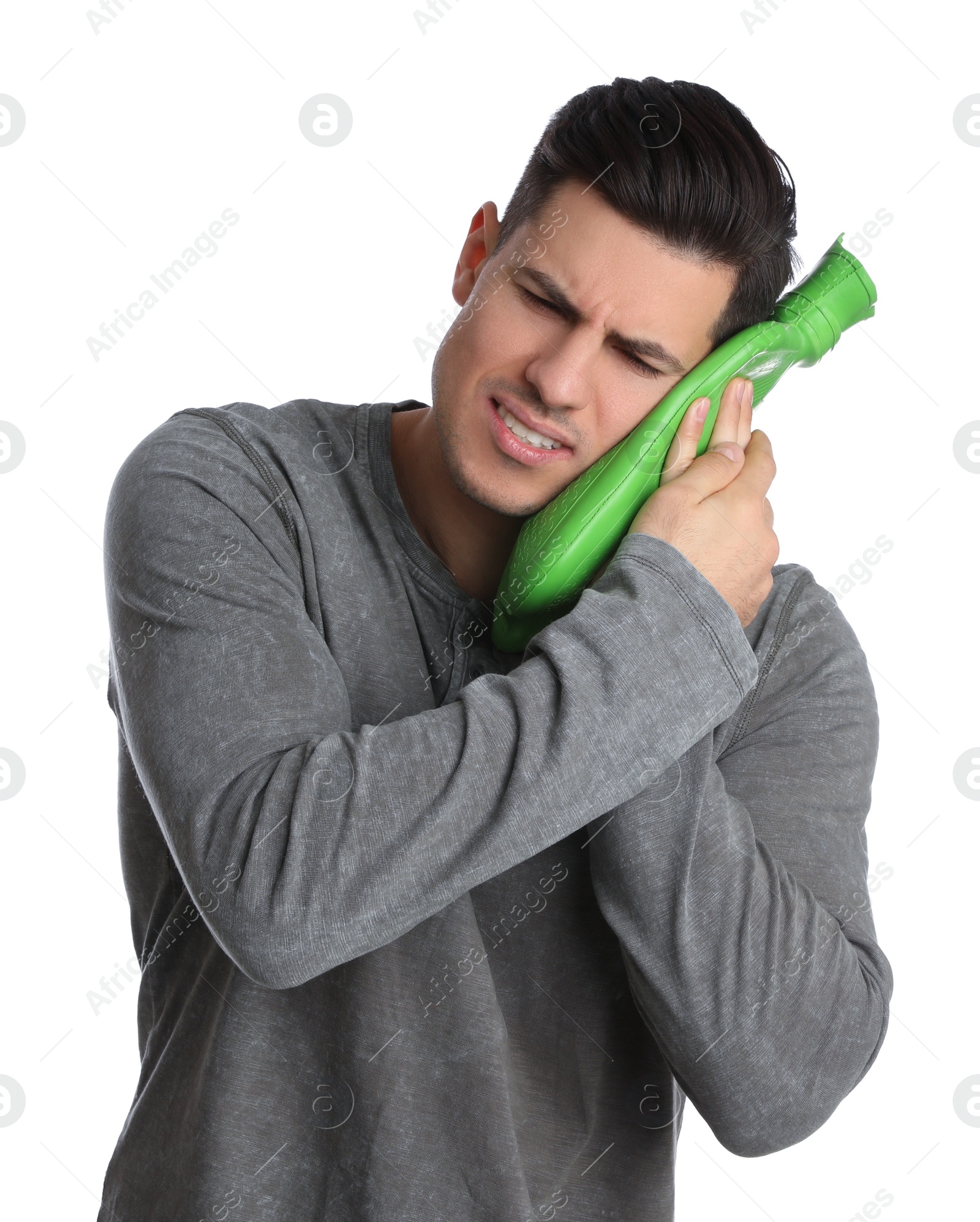 Photo of Man holding hot water bottle near face on white background