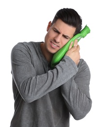 Man holding hot water bottle near face on white background