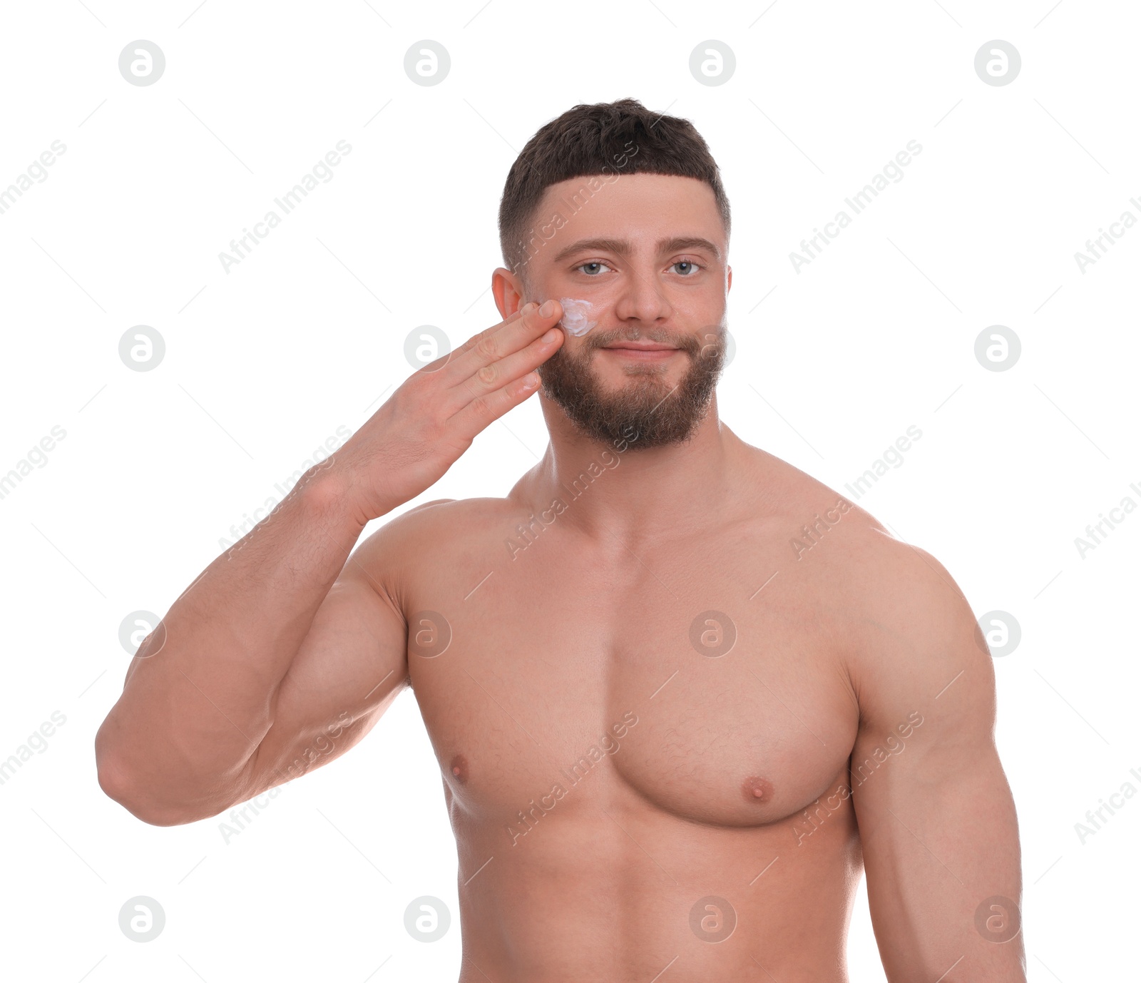 Photo of Handsome man applying cream onto his face on white background