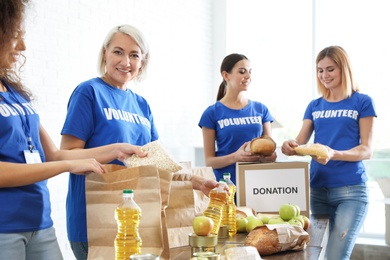 Team of volunteers collecting food donations indoors