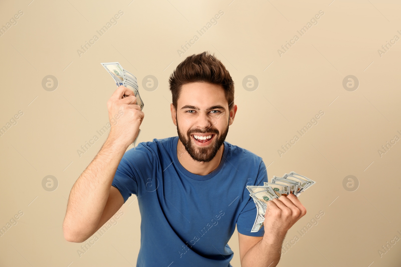 Photo of Portrait of happy young man with money on color background