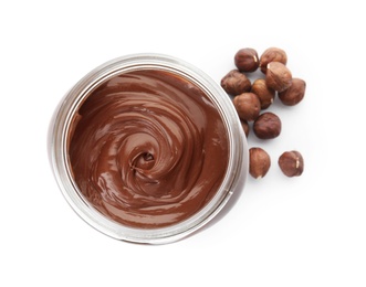 Glass jar with tasty chocolate cream and hazelnuts isolated on white, top view