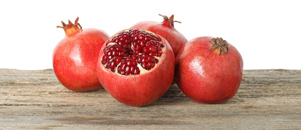 Fresh pomegranates on wooden table against white background