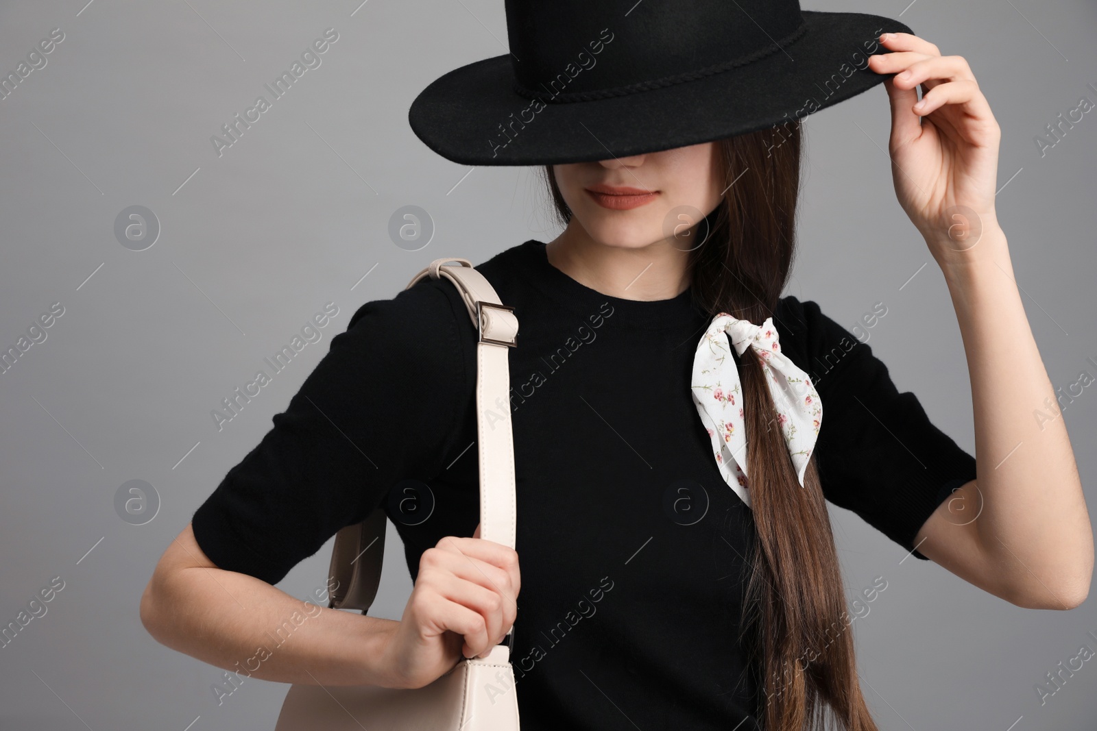 Photo of Young woman with hat and stylish bandana on grey background