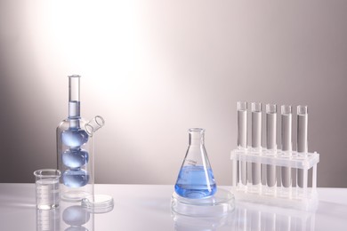 Laboratory analysis. Different glassware on table against light background