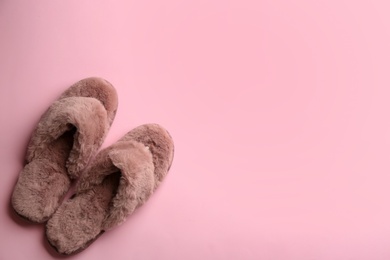 Photo of Pair of stylish soft slippers on pink background, flat lay. Space for text