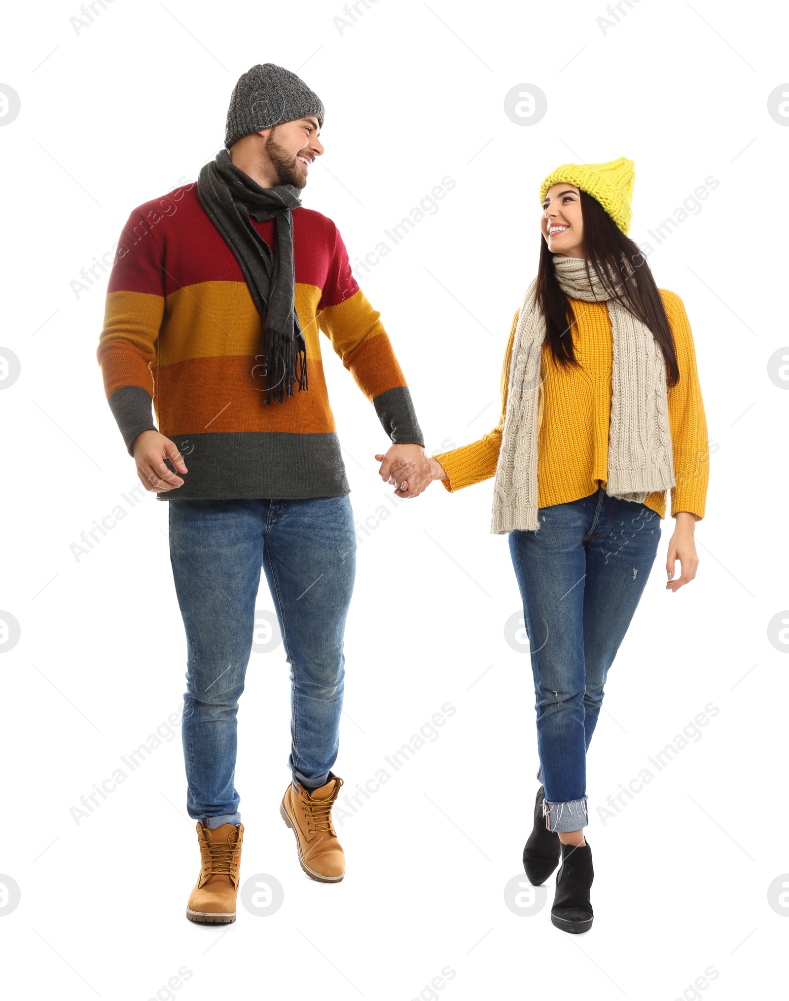 Photo of Happy young couple in warm clothes on white background. Winter vacation