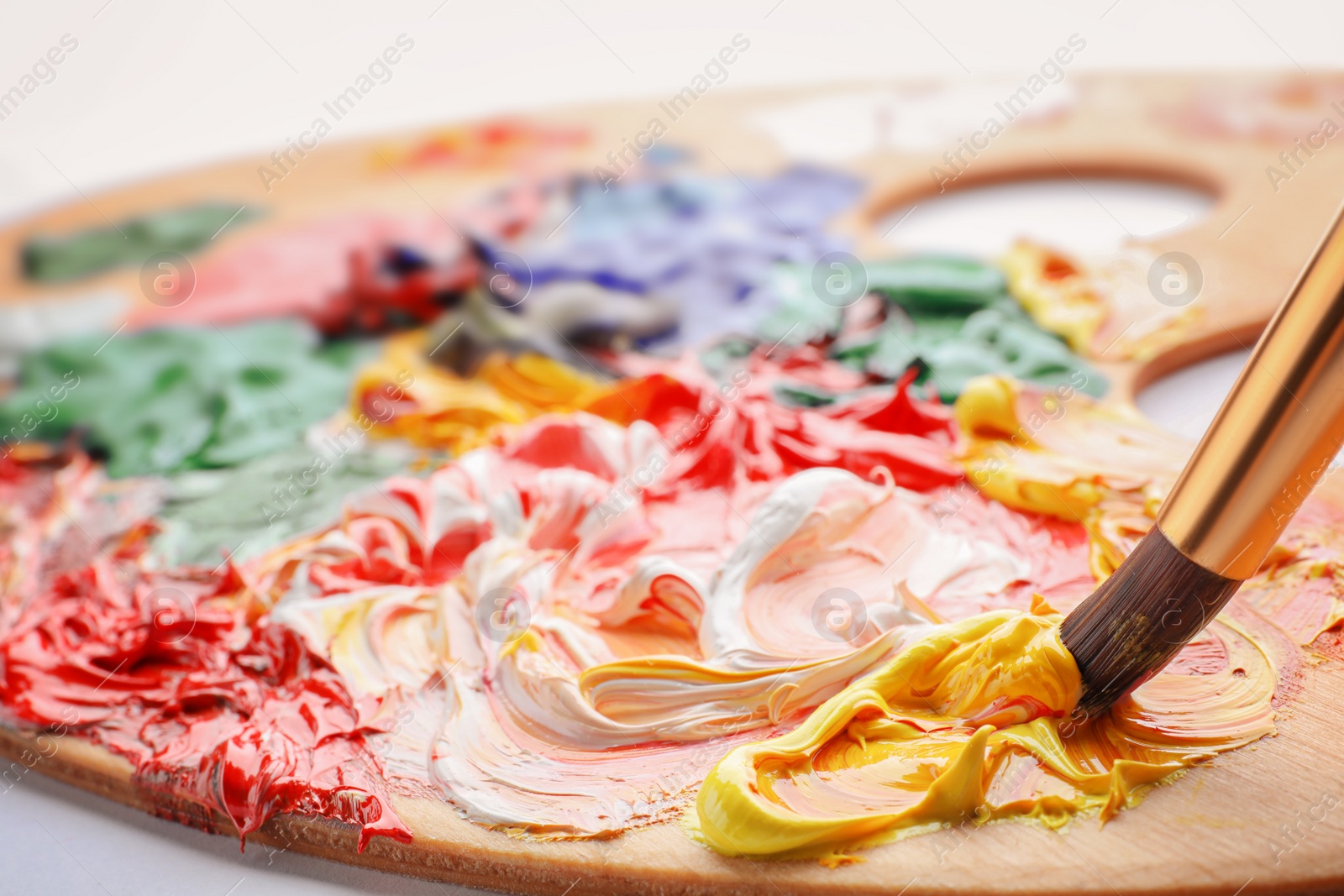 Photo of Mixing acrylic paints with brush, closeup. Color palette