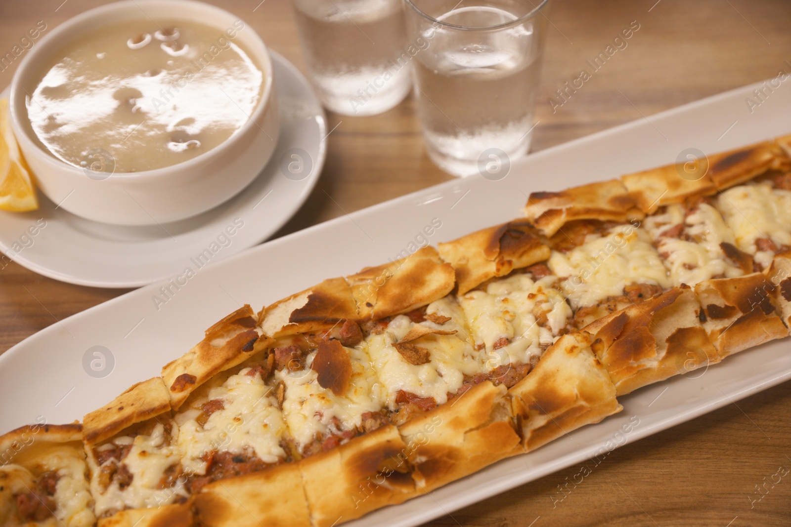 Photo of Delicious pide on wooden table, closeup. Traditional Turkish street food