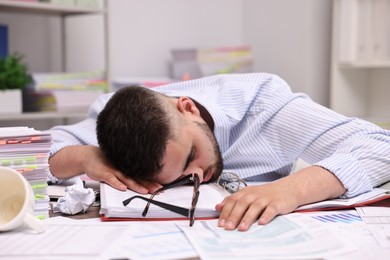 Office worker sleeping at workplace. Overwhelmed by work
