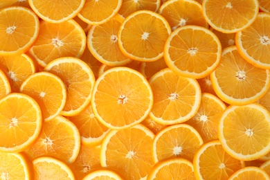 Many sliced fresh ripe oranges as background, top view