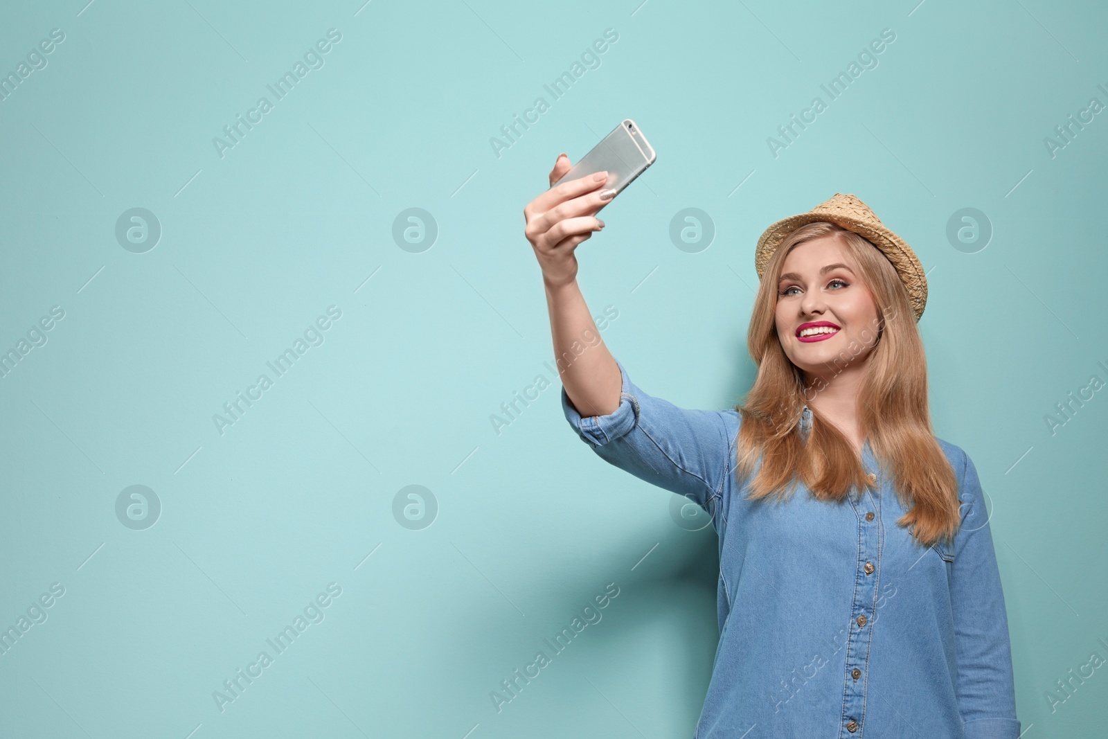 Photo of Attractive young woman taking selfie on color background