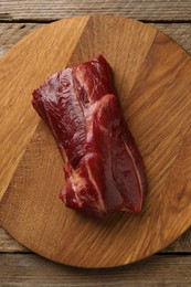 Photo of Piece of raw beef meat on wooden table, top view