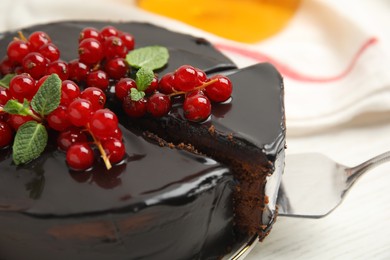 Tasty homemade chocolate cake with berries and mint on white table, closeup