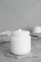 Jar of hand cream on gray marble table