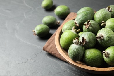 Delicious fresh feijoas on black table, closeup. Space for text
