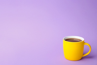 Photo of Yellow ceramic cup with hot aromatic coffee on color background