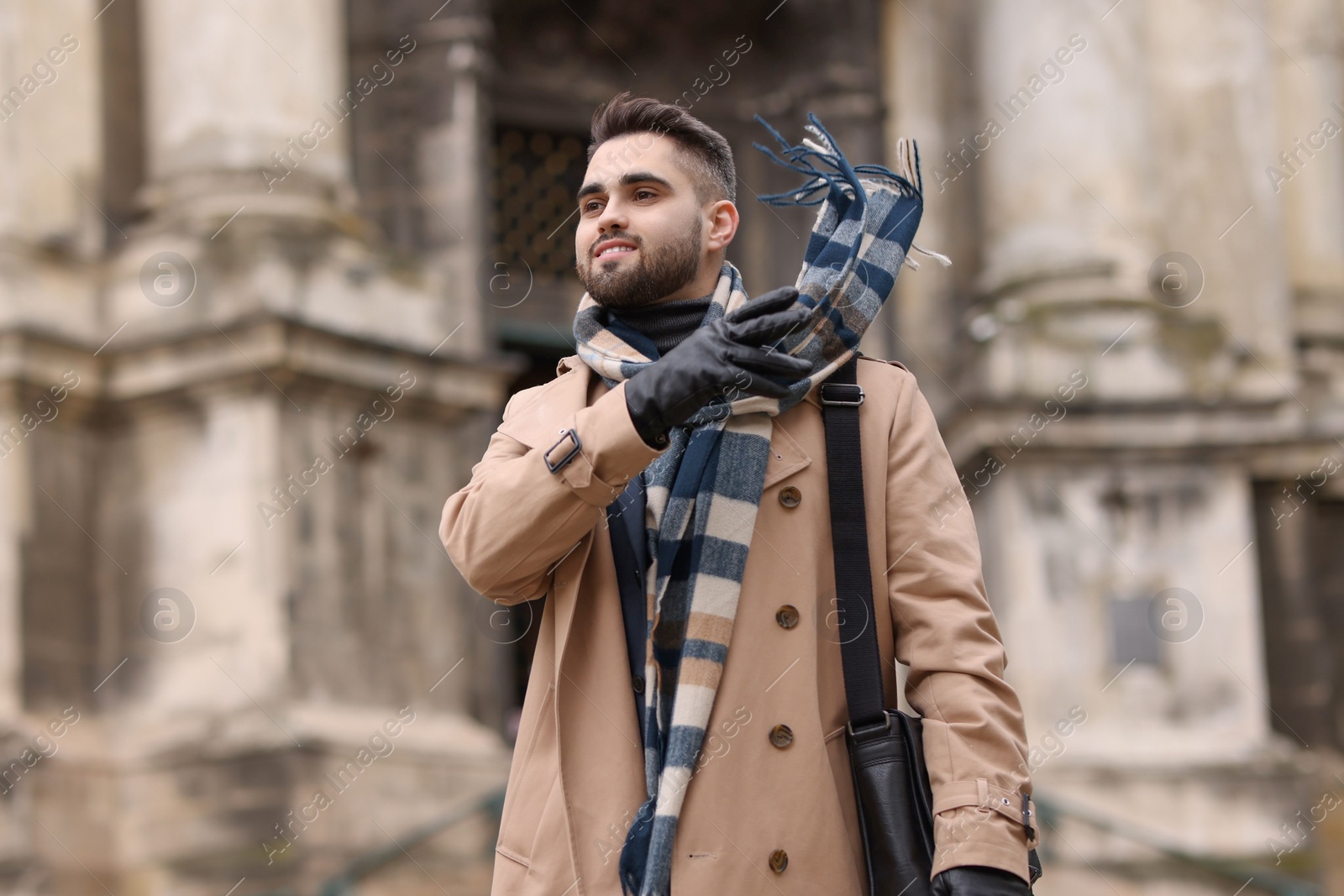 Photo of Smiling man in warm scarf on city street