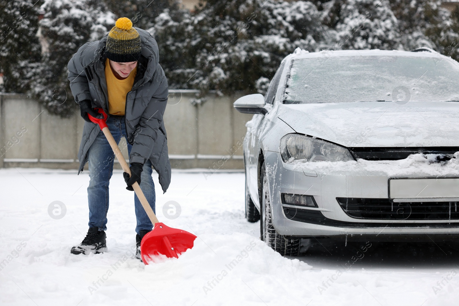 Photo of Man removing snow with shovel near car outdoors