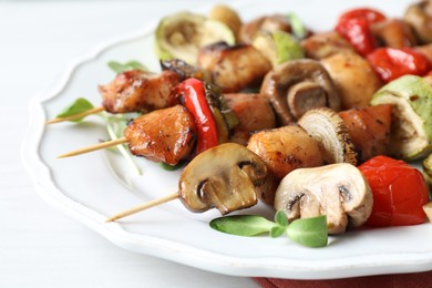 Photo of Delicious shish kebabs with vegetables and microgreens on table, closeup