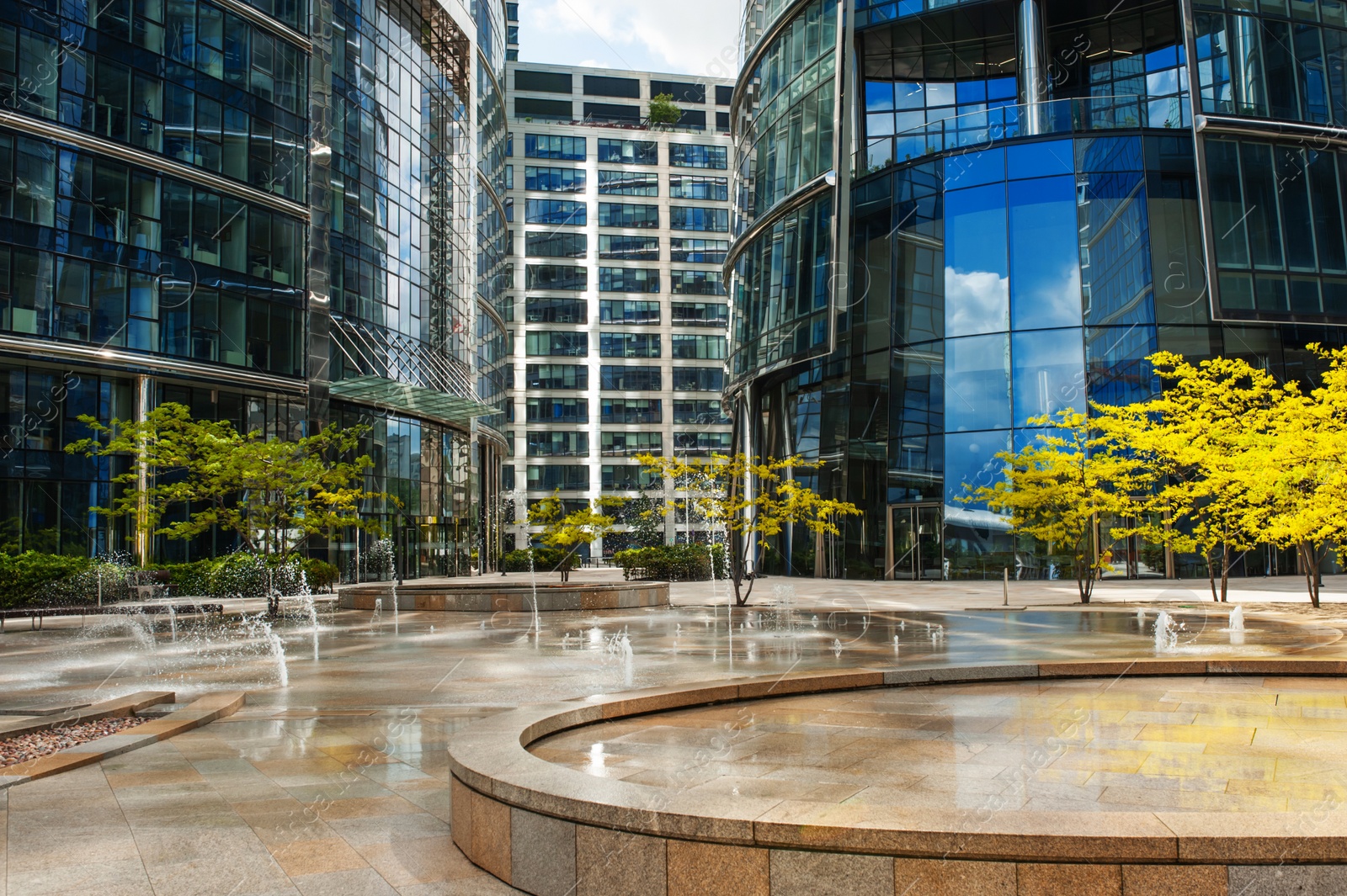 Photo of Beautiful fountain and trees near buildings in city