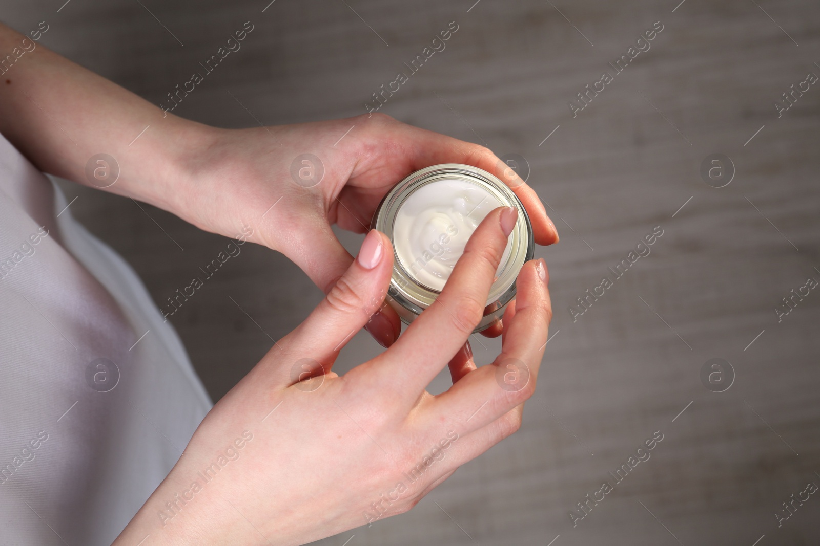 Photo of Woman applying hand cream indoors, above view