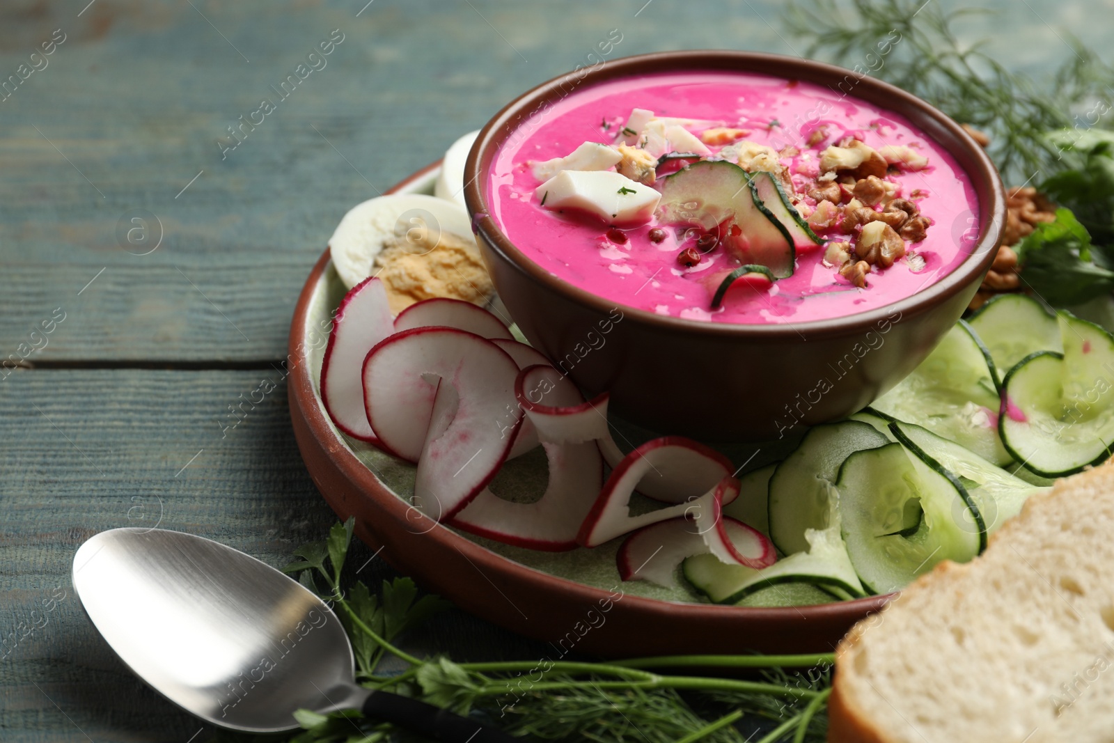 Photo of Delicious cold summer beet soup on blue wooden table