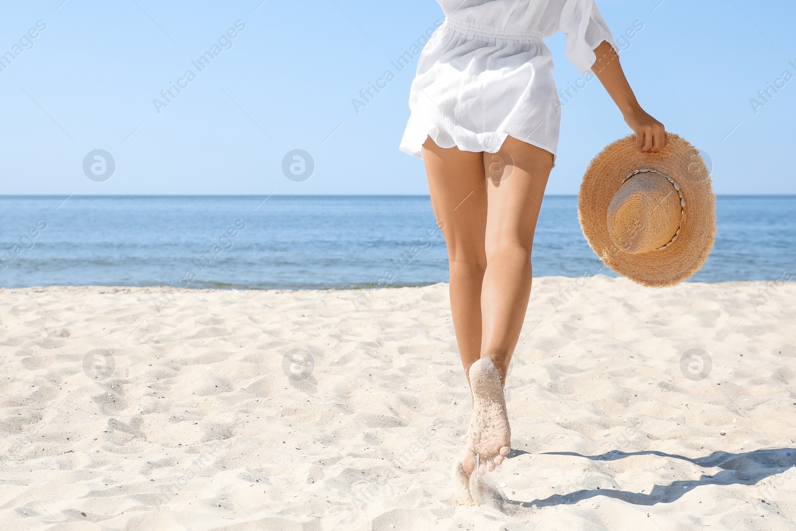 Photo of Young woman with beautiful body on beach, closeup. Space for text