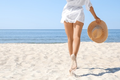 Photo of Young woman with beautiful body on beach, closeup. Space for text