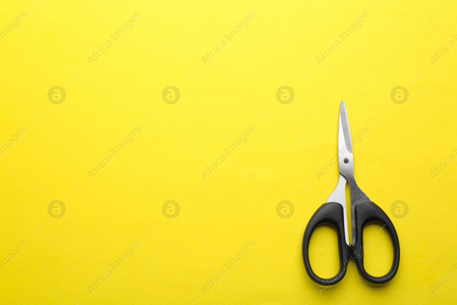 Photo of Pair of sharp scissors on color background, top view. Space for text