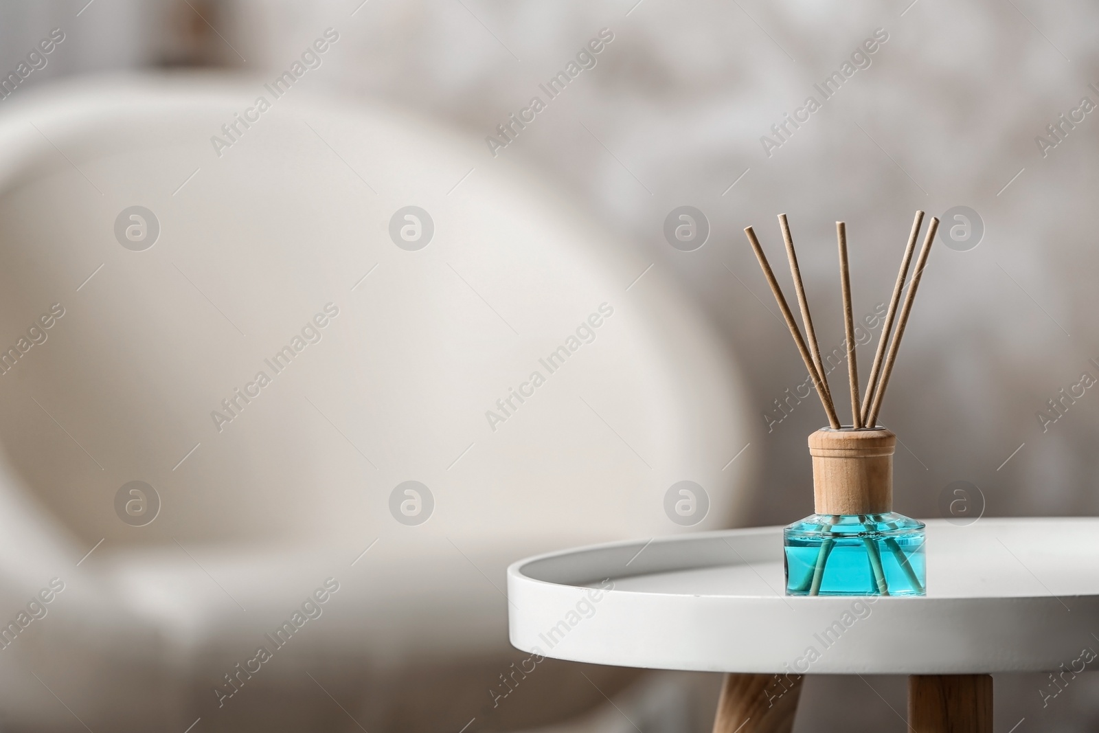 Photo of Reed air freshener on white table indoors, space for text