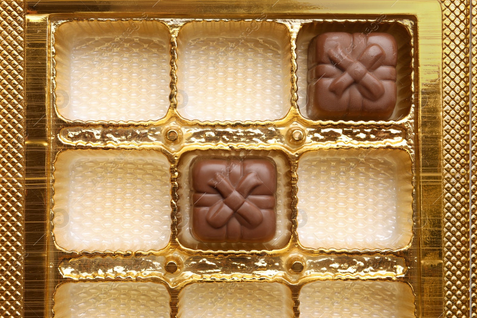 Photo of Partially empty box of chocolate candies as background, top view