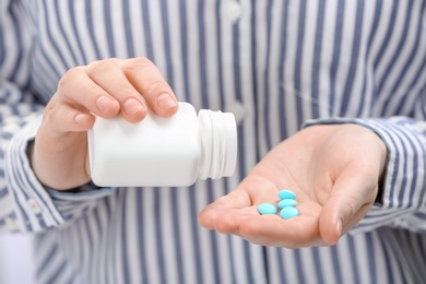 Photo of Young woman with bottle of pills, closeup