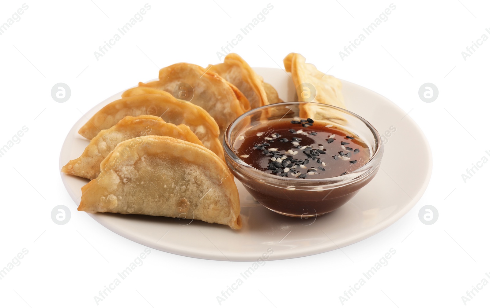 Photo of Delicious gyoza (asian dumplings) with soy sauce and sesame isolated on white