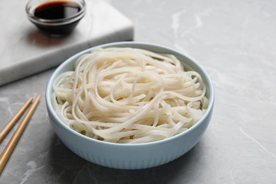 Photo of Bowl of rice cooked noodles served on grey table