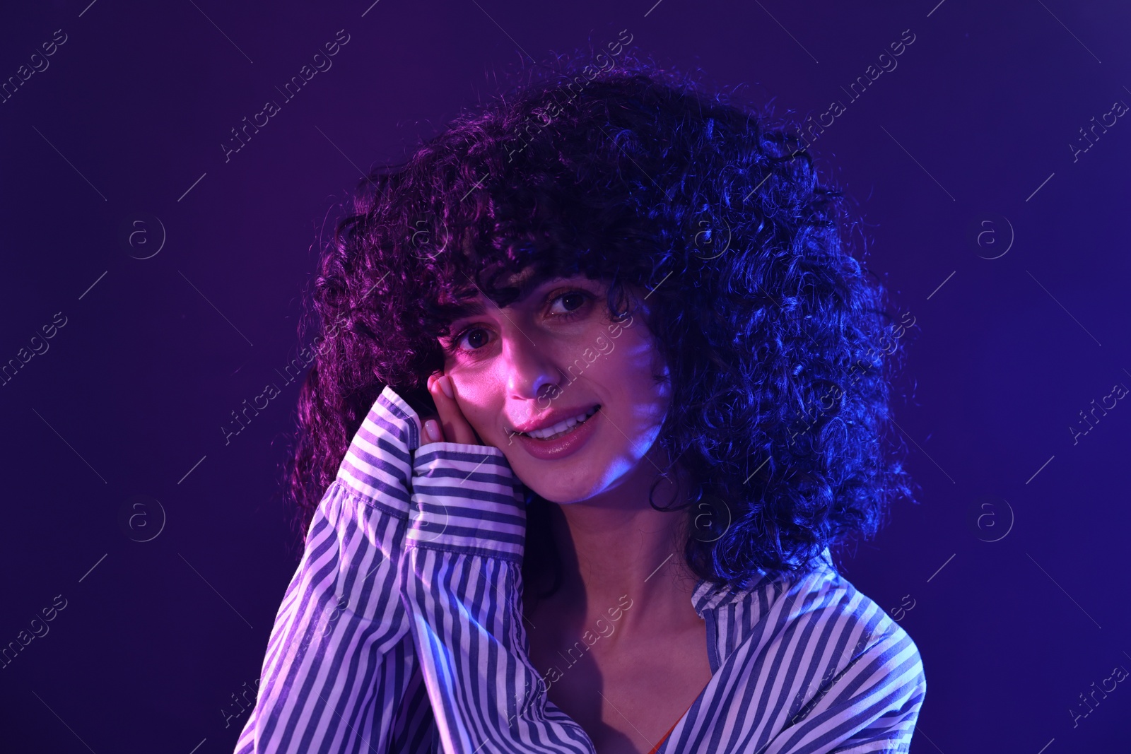 Photo of Beautiful young woman posing on color background in neon lights