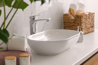 Stylish vessel sink on light countertop in modern bathroom