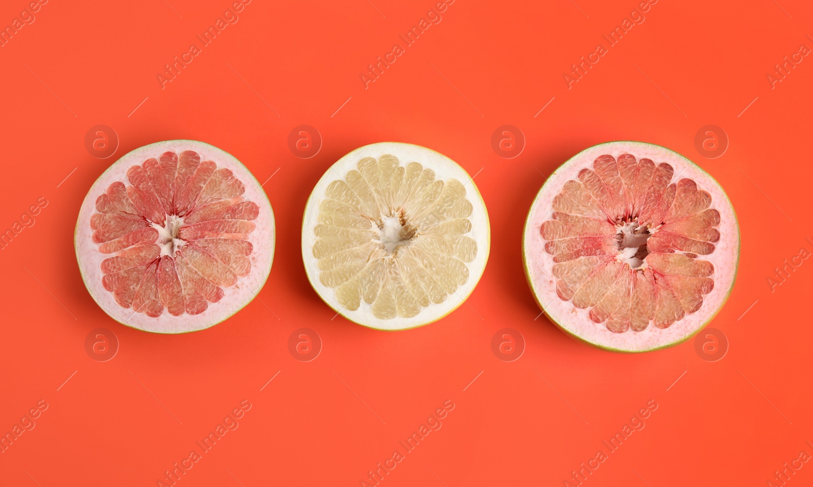 Photo of Fresh cut pomelo fruits on red background, flat lay