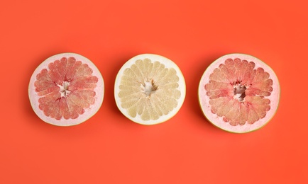 Photo of Fresh cut pomelo fruits on red background, flat lay