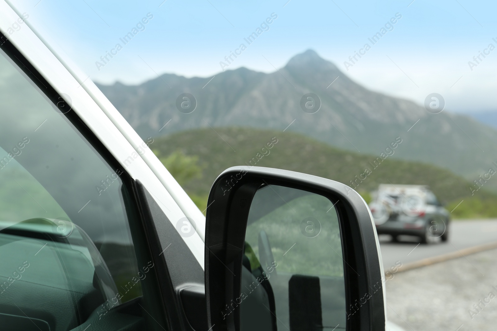 Photo of Beautiful view of car on asphalt highway in mountains, closeup. Road trip