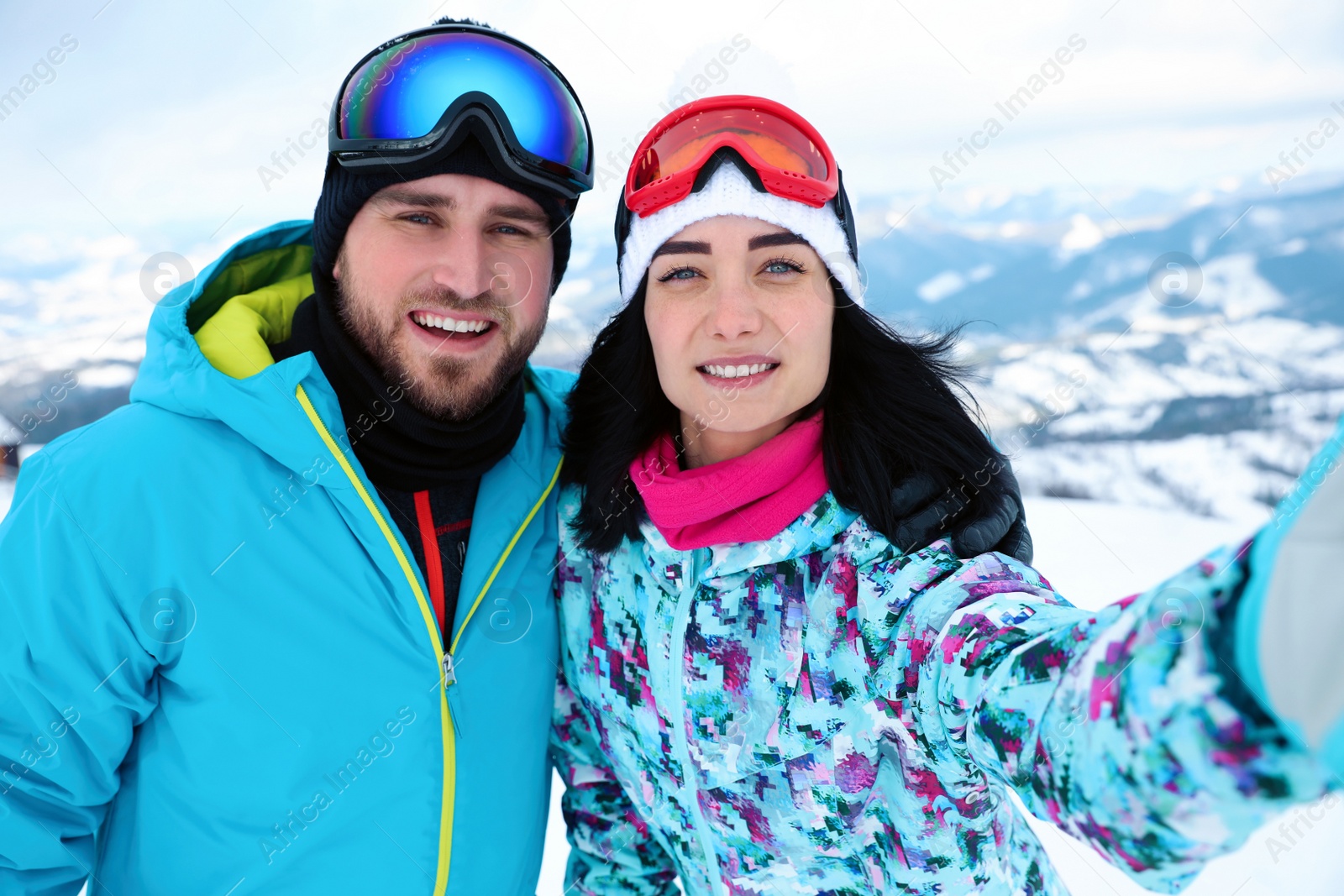Photo of Young couple taking selfie at mountain resort. Winter vacation
